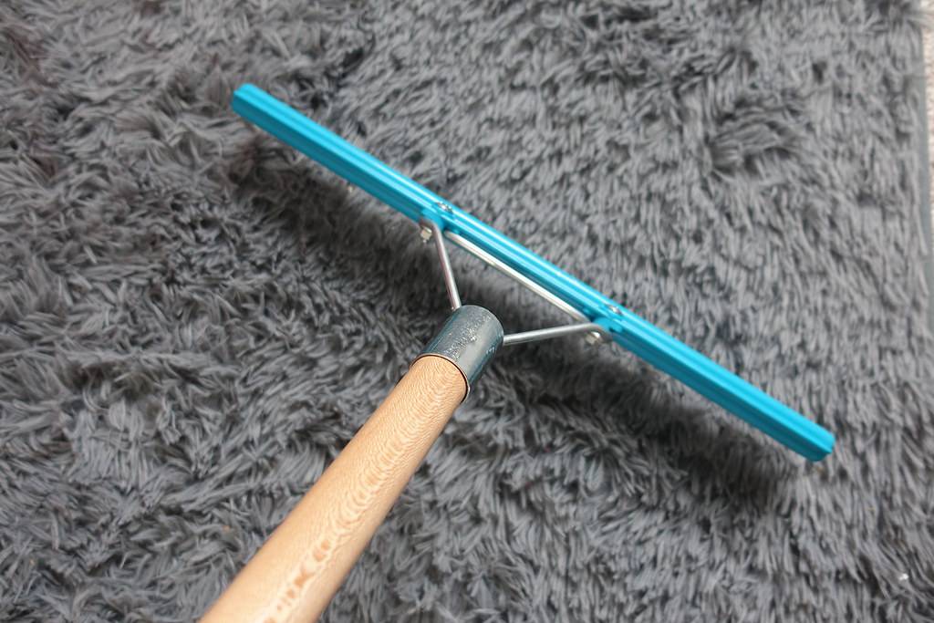 Carpet rake being used on shag rug